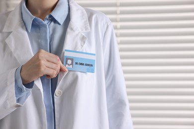 Photo of Doctor with badge in clinic, closeup. Space for text