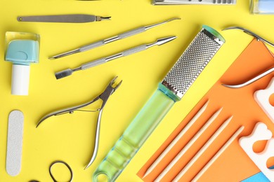 Photo of Set of pedicure tools on color background, flat lay