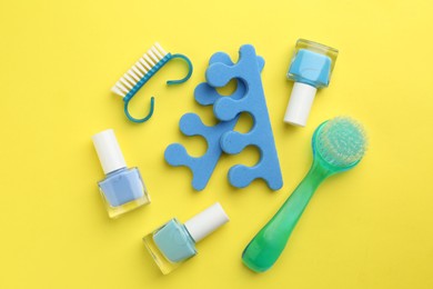 Photo of Set of pedicure tools on yellow background, flat lay