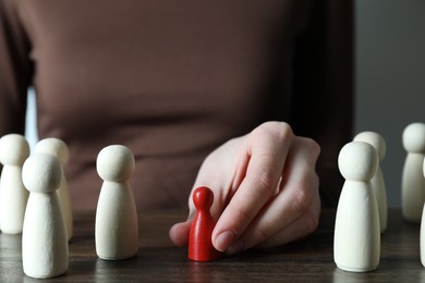 Photo of Human resources concept. Woman choosing red piece between other ones at table, closeup