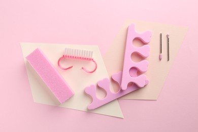 Photo of Set of pedicure tools on pink background, flat lay