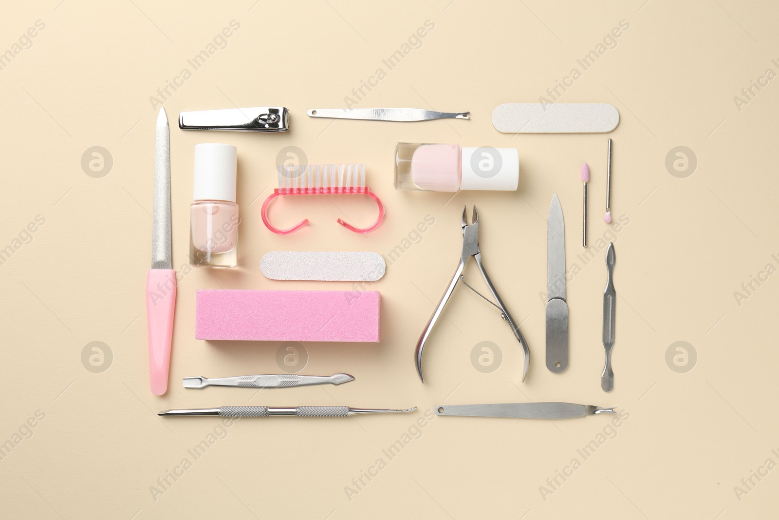 Photo of Set of pedicure tools on beige background, flat lay