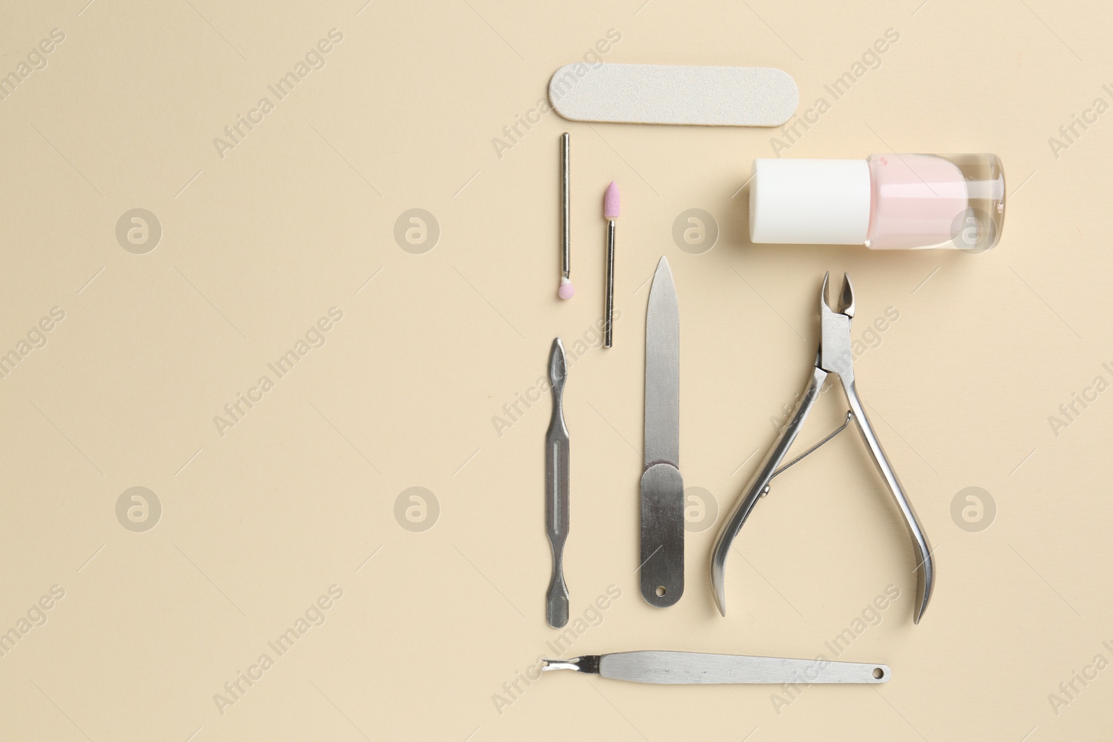 Photo of Set of pedicure tools on beige background, flat lay. Space for text