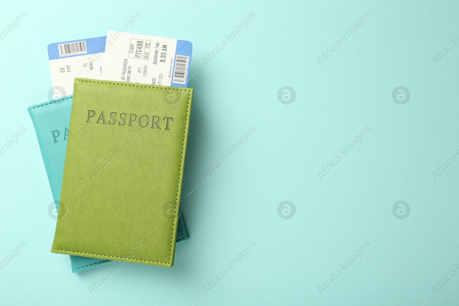 Photo of Passports with tickets on light blue background, top view. Space for text