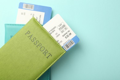 Photo of Passports with tickets on light blue background, top view. Space for text