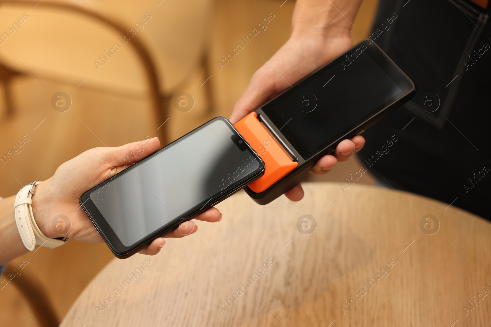 Photo of Woman paying with smartphone via terminal in cafe, closeup