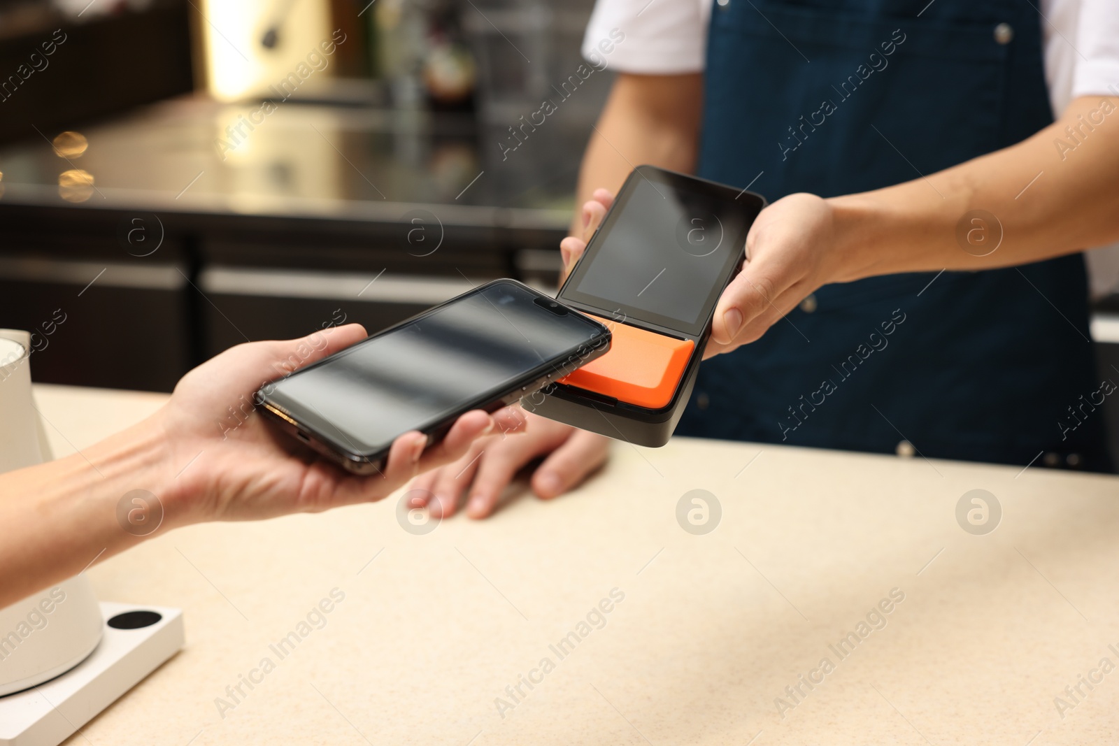 Photo of Woman paying with smartphone via terminal in cafe, closeup