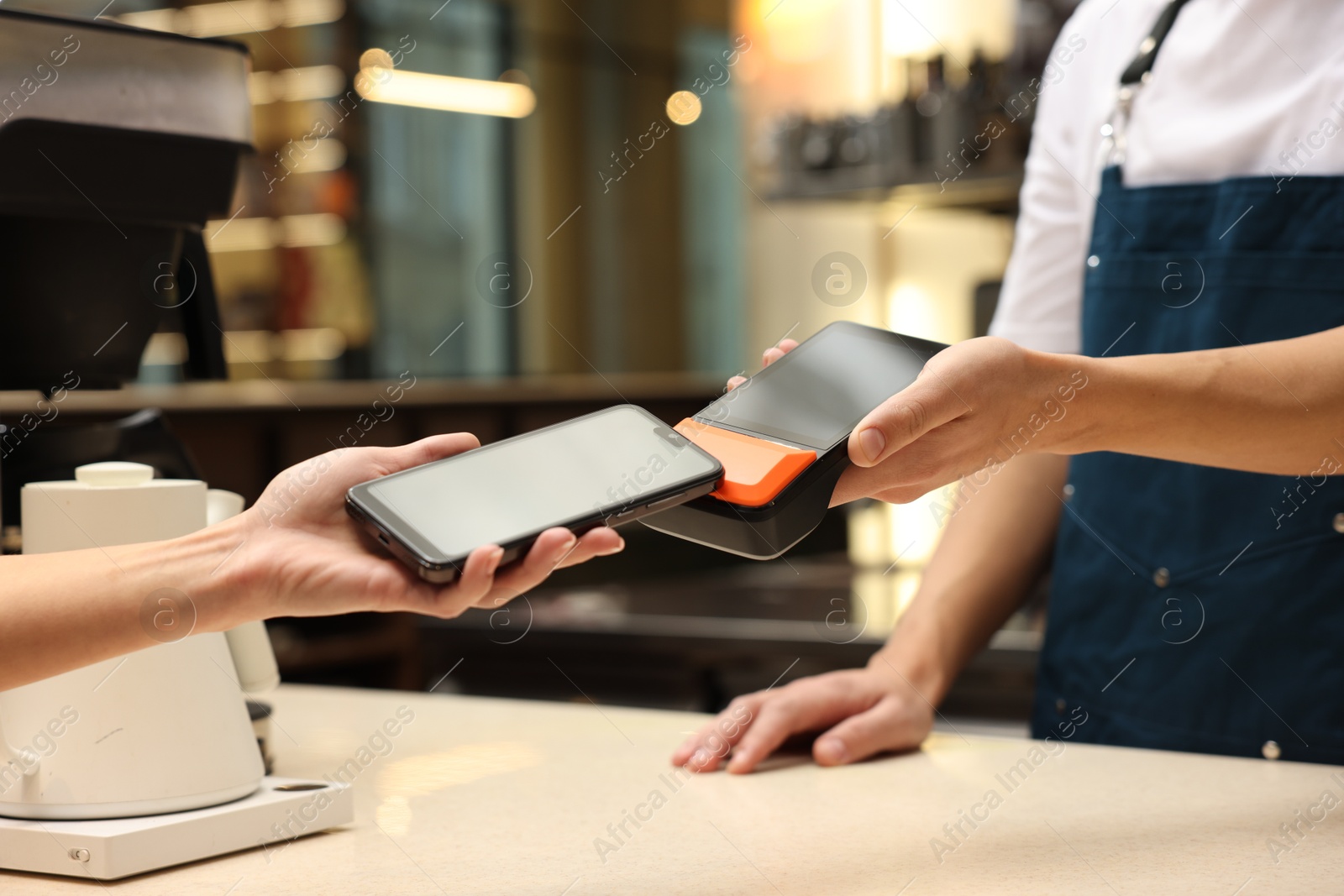 Photo of Woman paying with smartphone via terminal in cafe, closeup