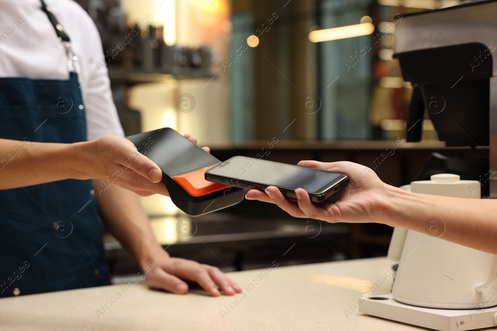 Photo of Woman paying with smartphone via terminal in cafe, closeup