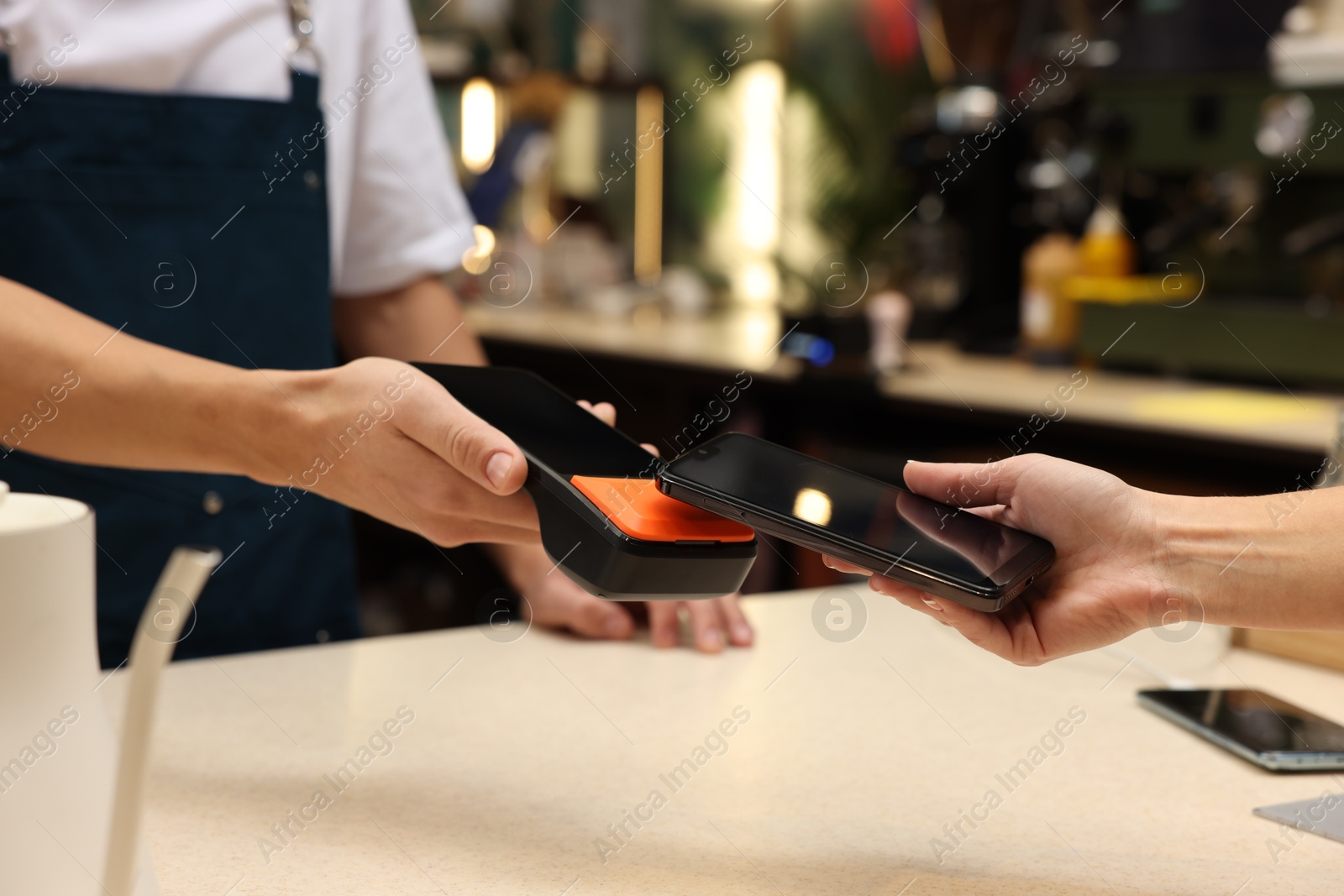 Photo of Woman paying with smartphone via terminal in cafe, closeup