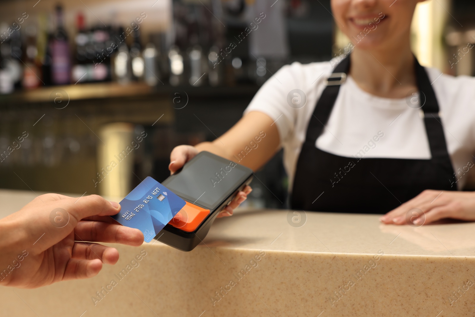 Photo of Man paying with credit card via terminal in cafe, closeup