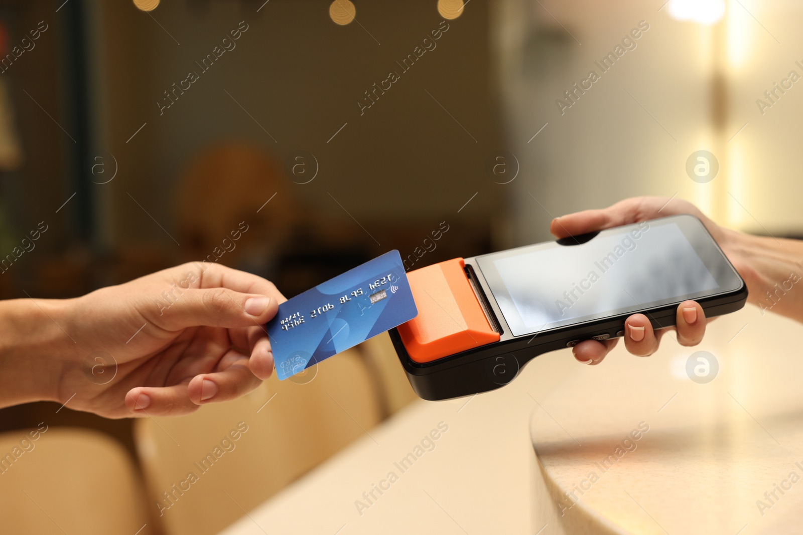 Photo of Man paying with credit card via terminal in cafe, closeup