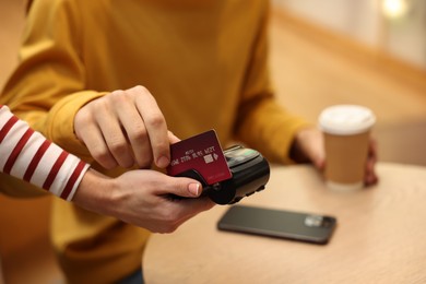 Photo of Man paying with credit card via terminal in cafe, closeup