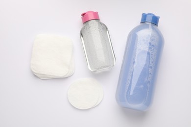 Photo of Clean cotton pads and micellar water on white background, flat lay