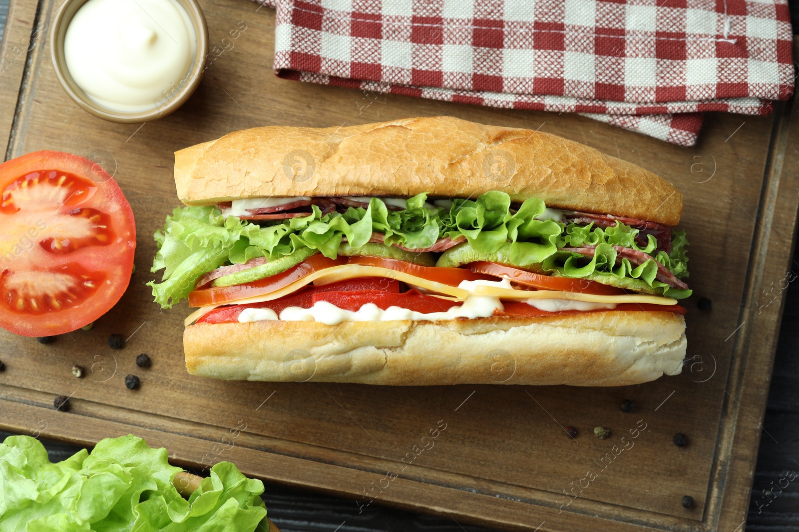 Photo of Delicious baguette sandwich with salami and cheese on table, flat lay