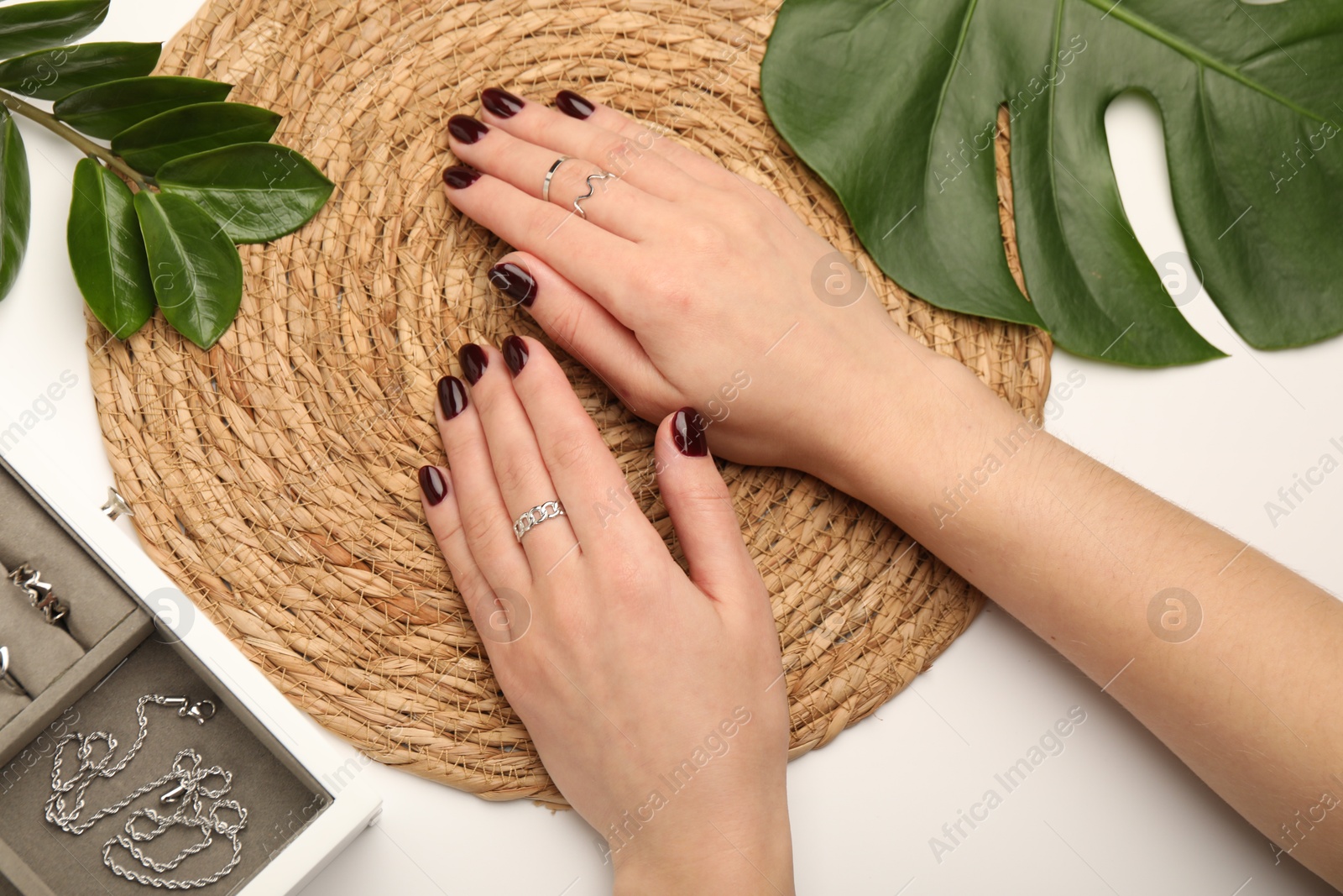 Photo of Woman wearing beautiful rings at white table, top view