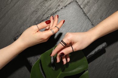 Women wearing beautiful rings on black background, closeup