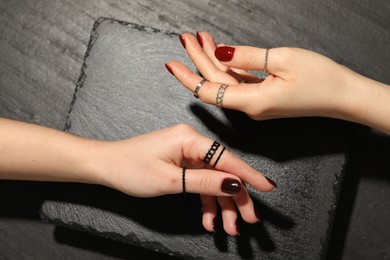 Photo of Women wearing beautiful rings on black background, closeup