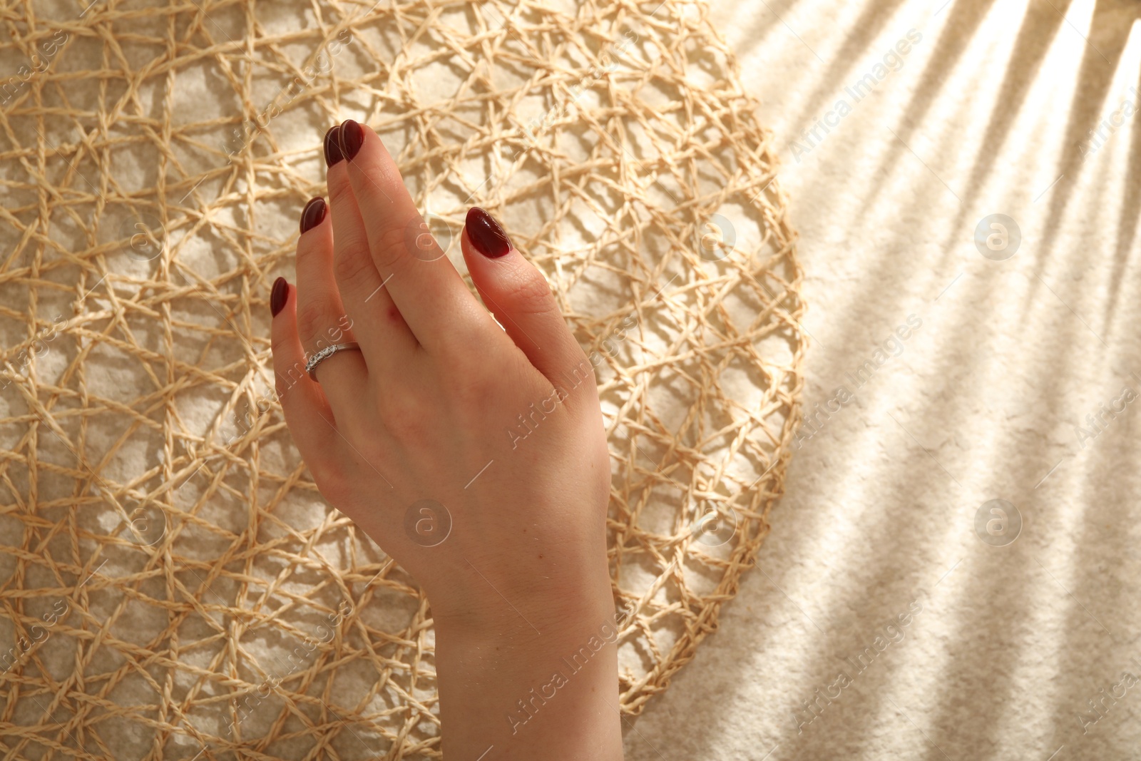 Photo of Woman wearing beautiful rings on beige background, closeup. Space for text