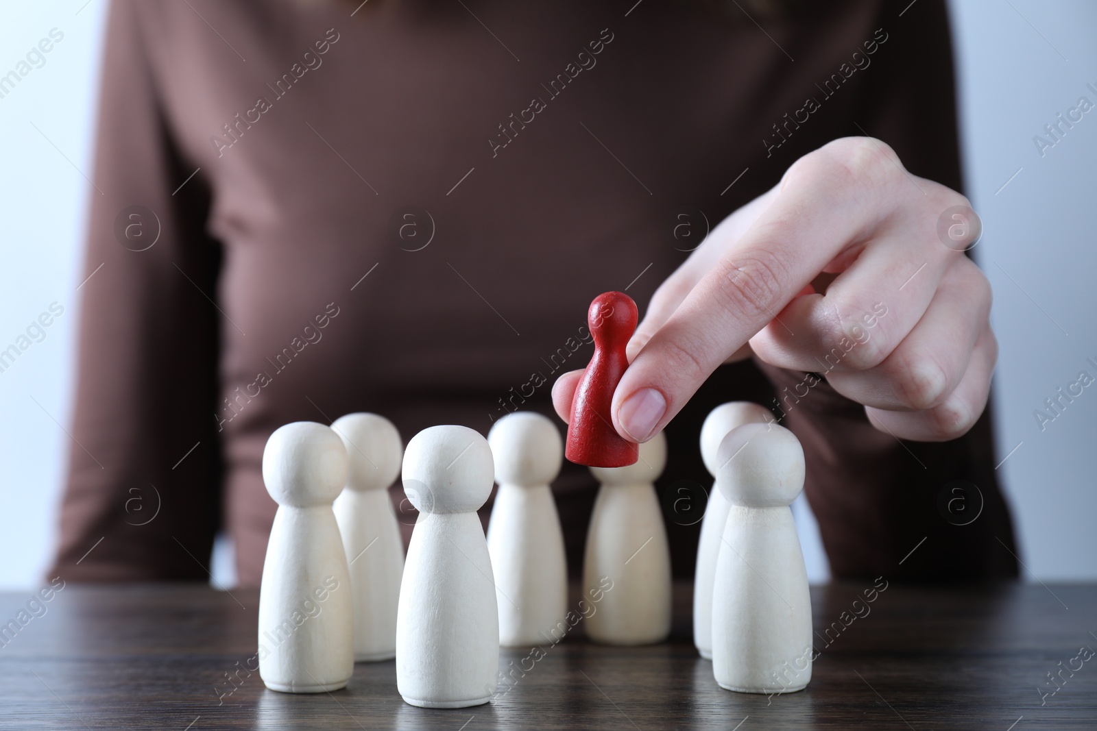 Photo of Human resources concept. Woman choosing red piece between other ones at table, closeup