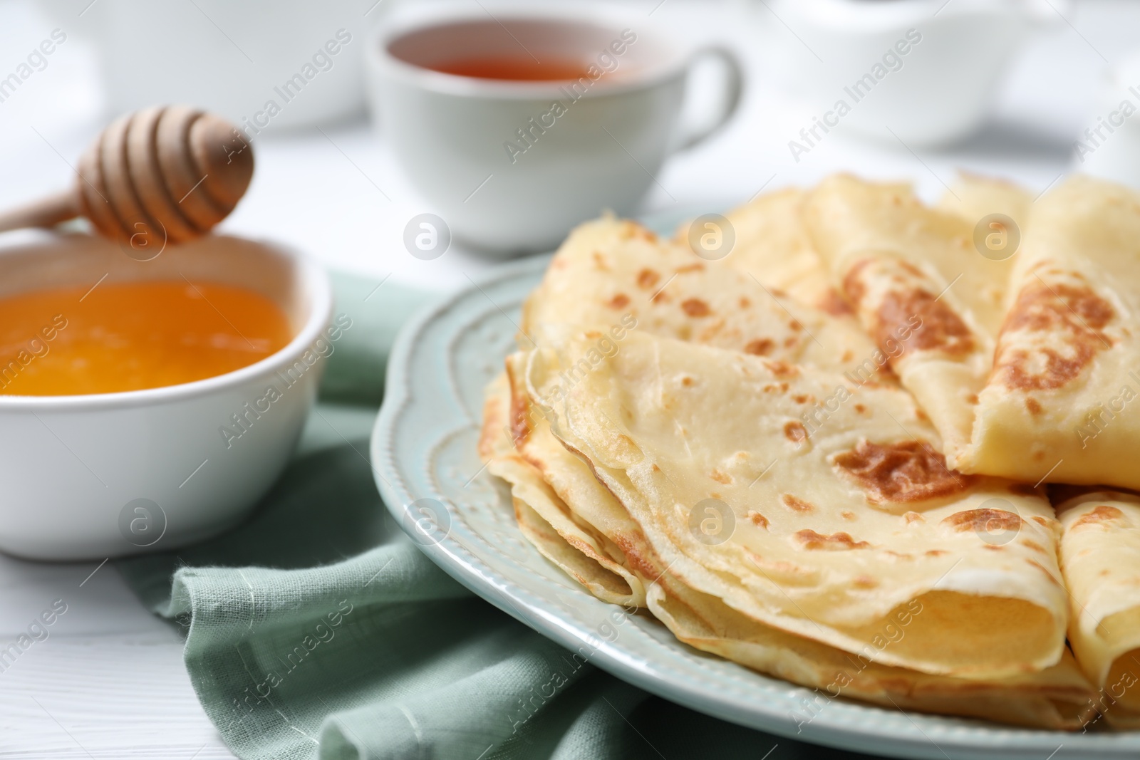 Photo of Delicious crepes served on white table, closeup