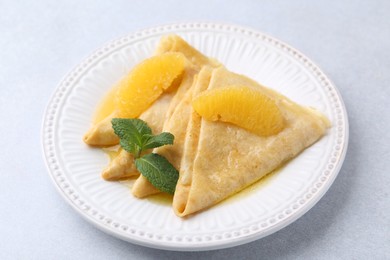 Photo of Delicious Crepes Suzette on light table, closeup