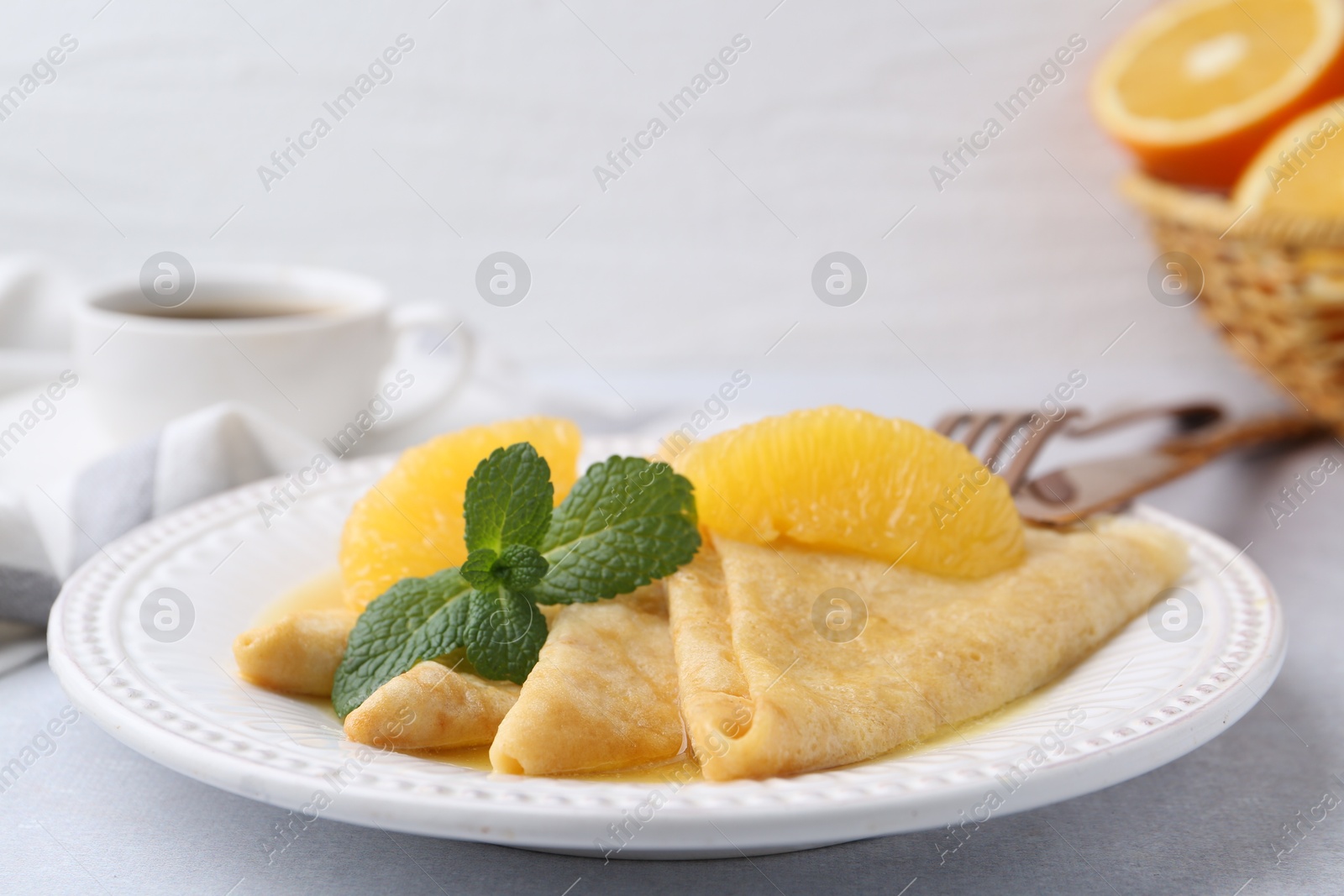 Photo of Delicious Crepes Suzette served on light table, closeup