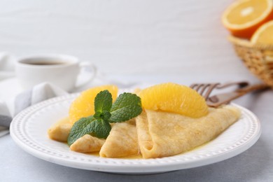 Photo of Delicious Crepes Suzette served on light table, closeup