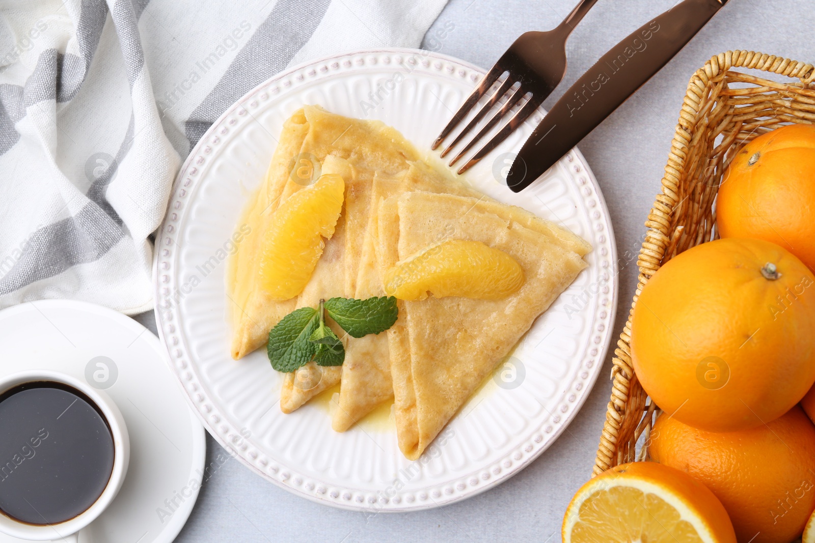 Photo of Delicious Crepes Suzette served on light table, flat lay