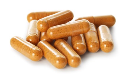 Photo of Many turmeric capsules isolated on white. Herbal dietary supplement