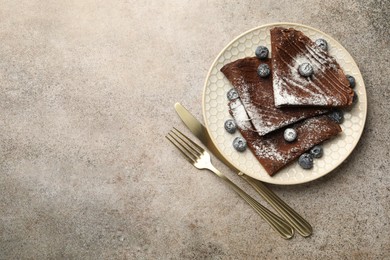 Photo of Delicious chocolate crepes with blueberries served on grey table, top view. Space for text