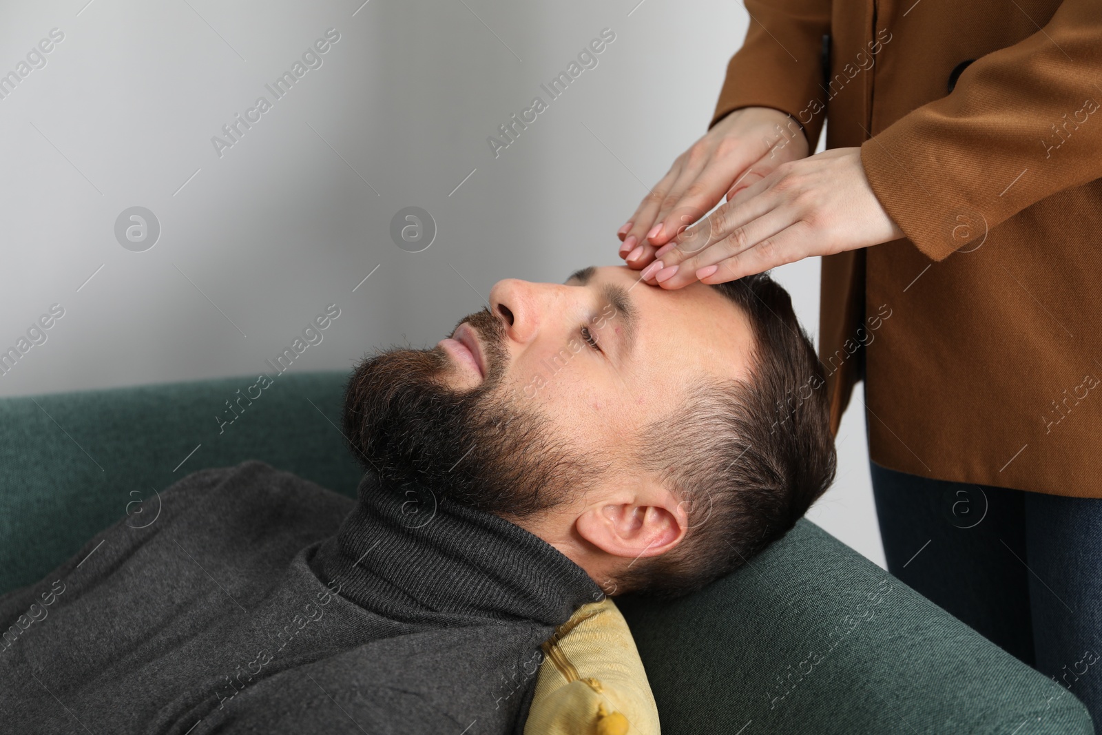 Photo of Psychologist working with patient during hypnosis session indoors, closeup