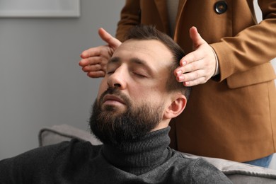 Photo of Psychologist working with patient during hypnosis session indoors, closeup