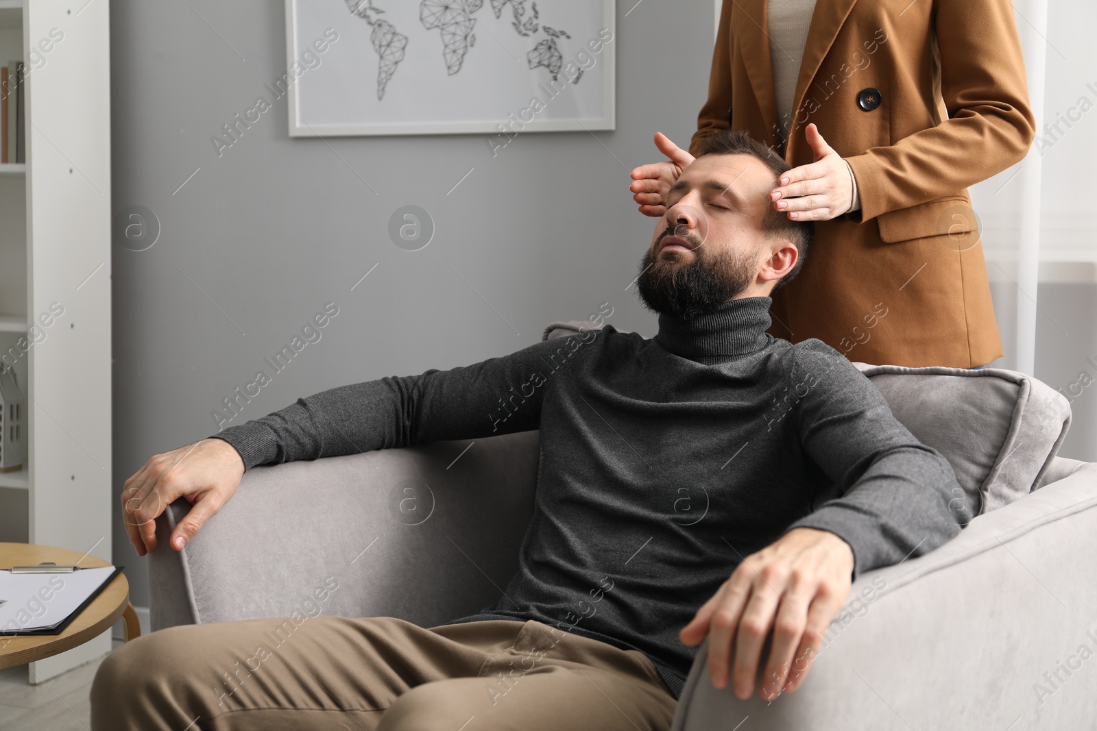 Photo of Psychologist working with patient during hypnosis session indoors, closeup