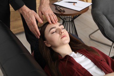 Photo of Psychologist working with patient during hypnosis session indoors, closeup