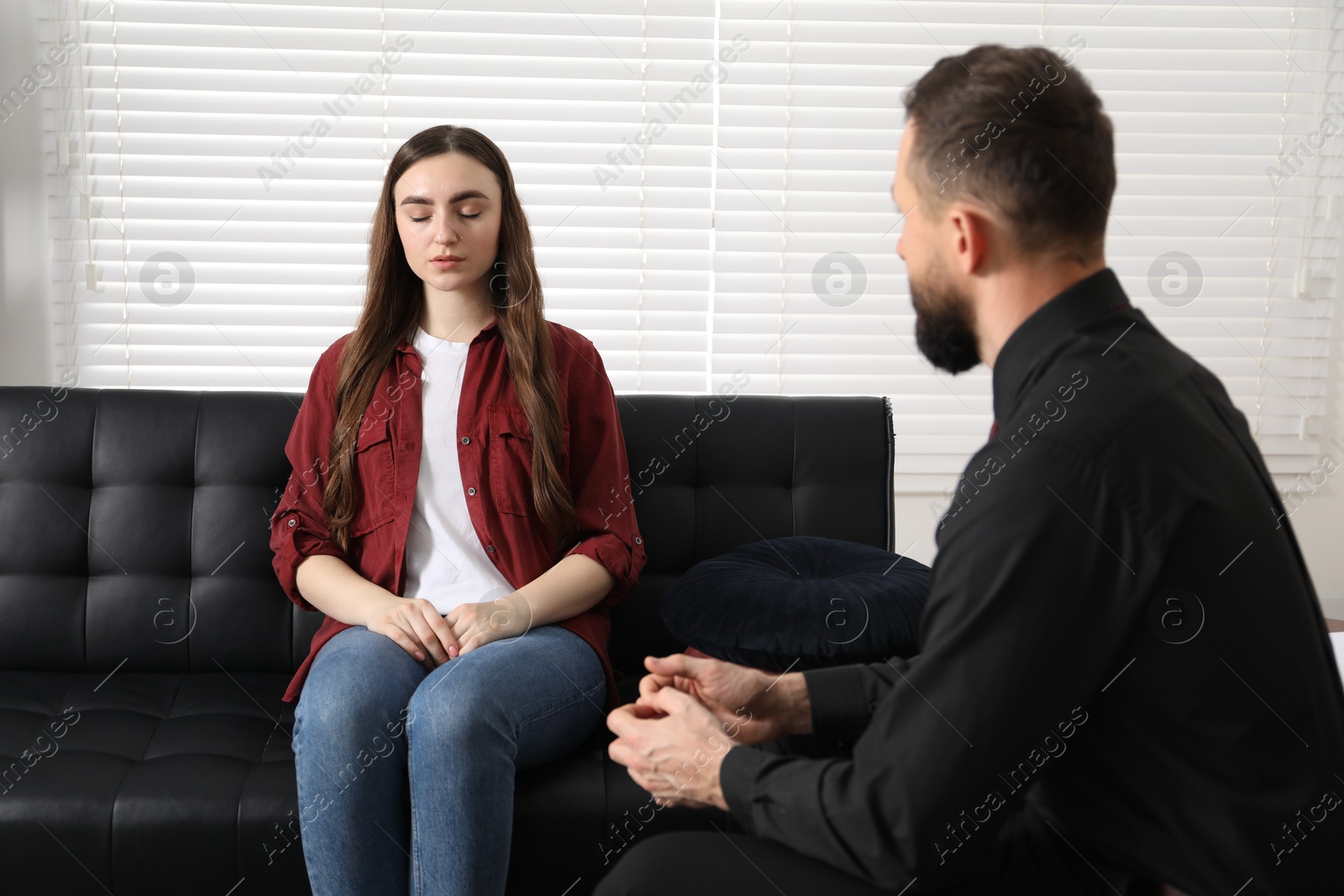 Photo of Psychologist working with patient during hypnosis session indoors