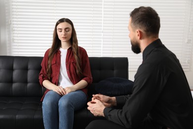 Photo of Psychologist working with patient during hypnosis session indoors