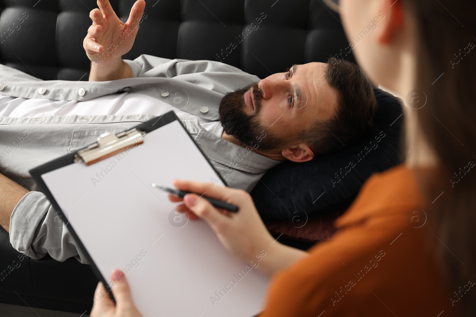 Photo of Psychologist working with patient during hypnosis session indoors, closeup