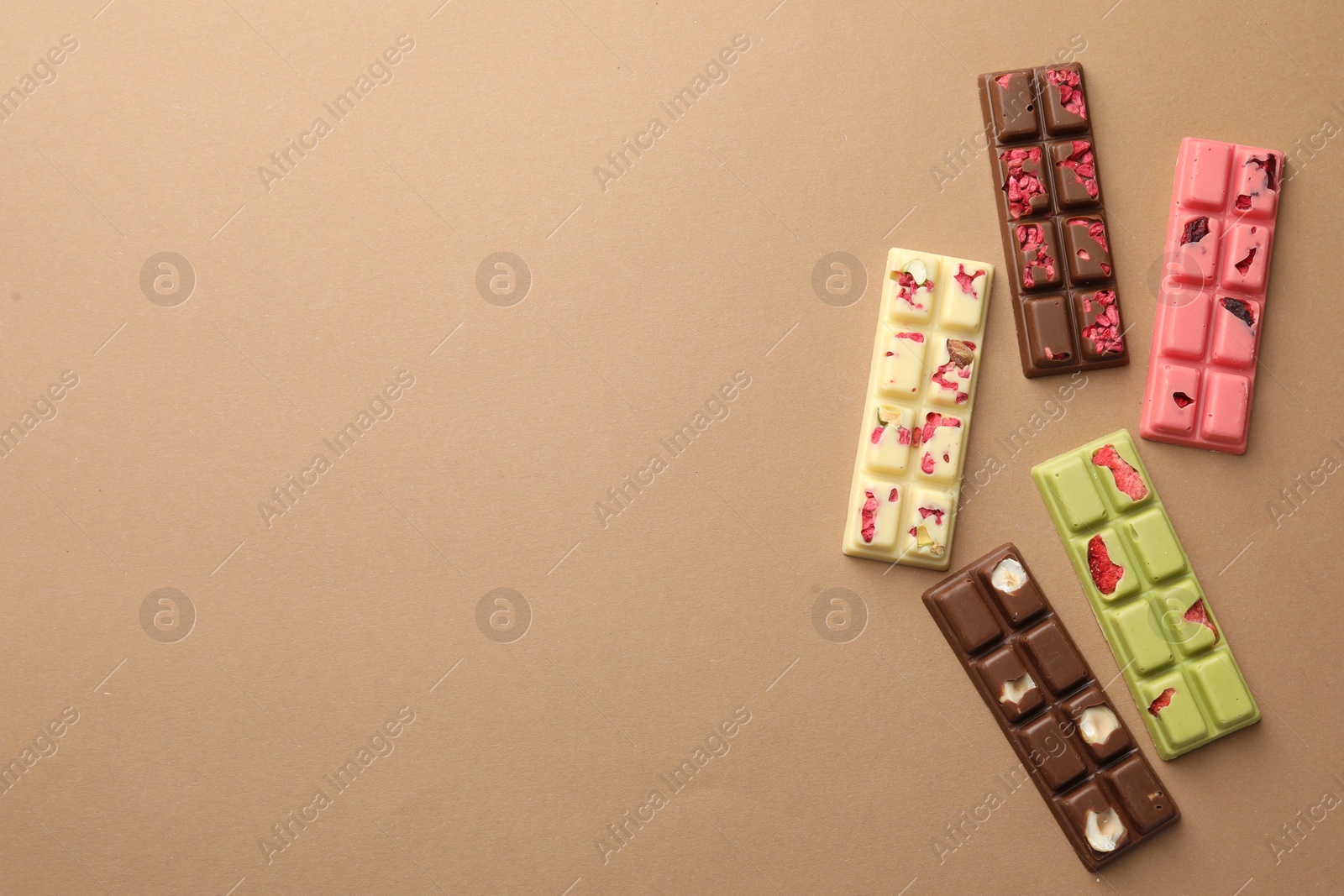 Photo of Different tasty chocolate bars on beige background, flat lay. Space for text