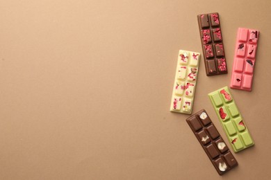 Photo of Different tasty chocolate bars on beige background, flat lay. Space for text