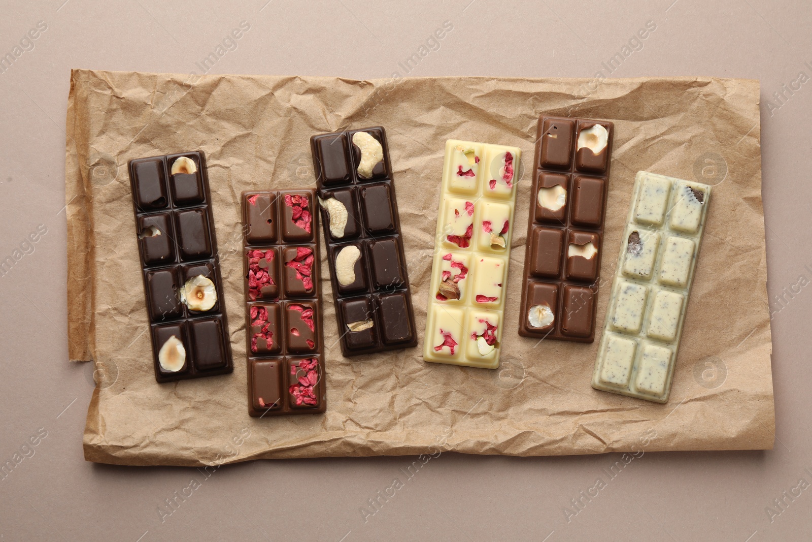 Photo of Different tasty chocolate bars on beige background, top view