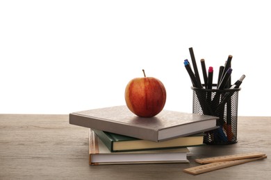 Photo of Doing homework. Notebooks, apple and different stationery on wooden table against white background