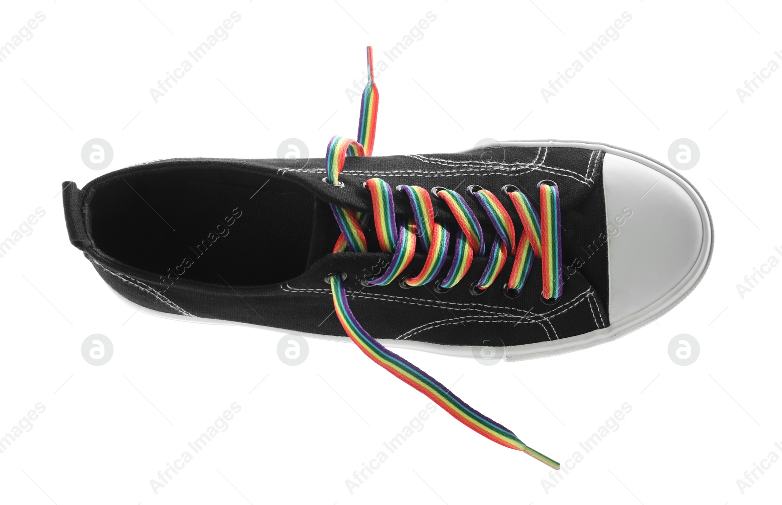 Photo of Black shoe with bright rainbow lace on white background, top view. LGBT concept