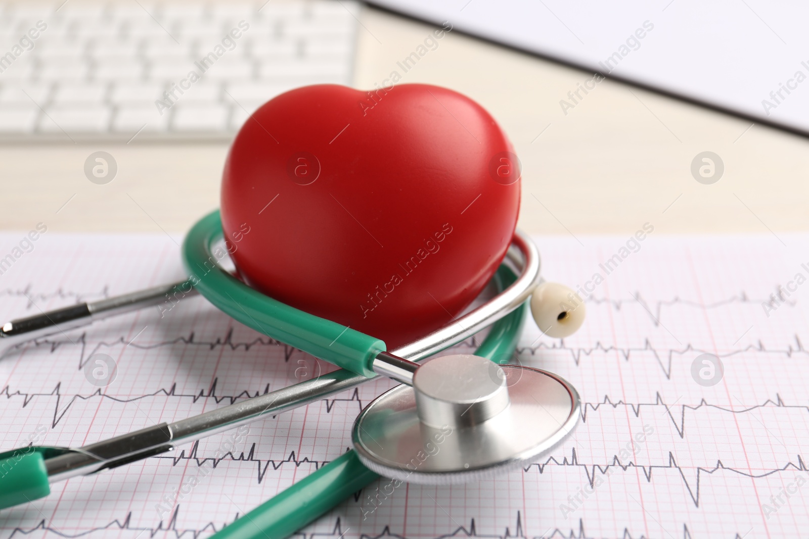 Photo of Cardiology. Stethoscope, cardiogram and red decorative heart on light table, closeup