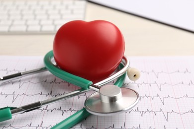 Photo of Cardiology. Stethoscope, cardiogram and red decorative heart on light table, closeup