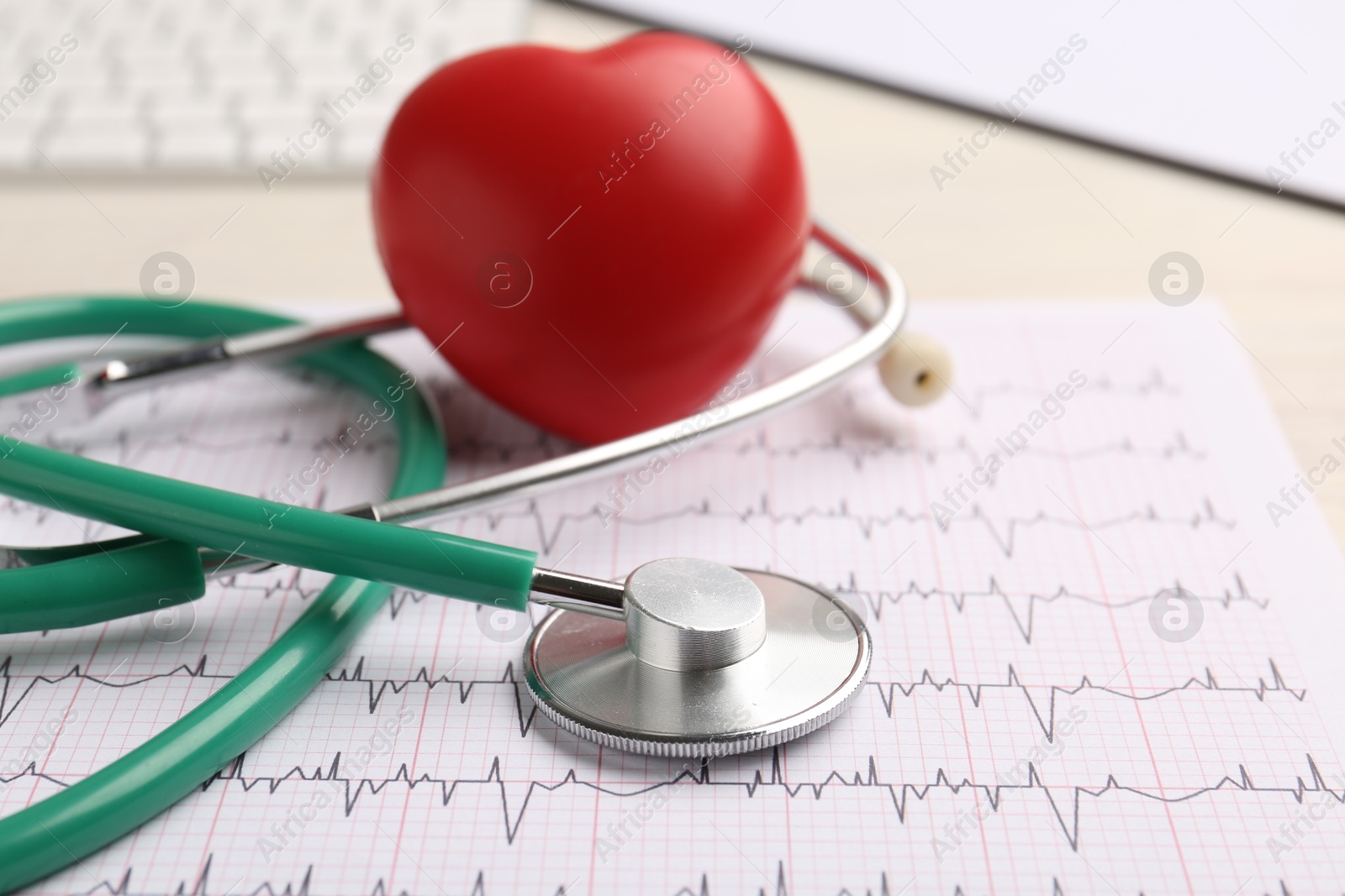 Photo of Cardiology. Stethoscope, cardiogram and red decorative heart on light table, closeup