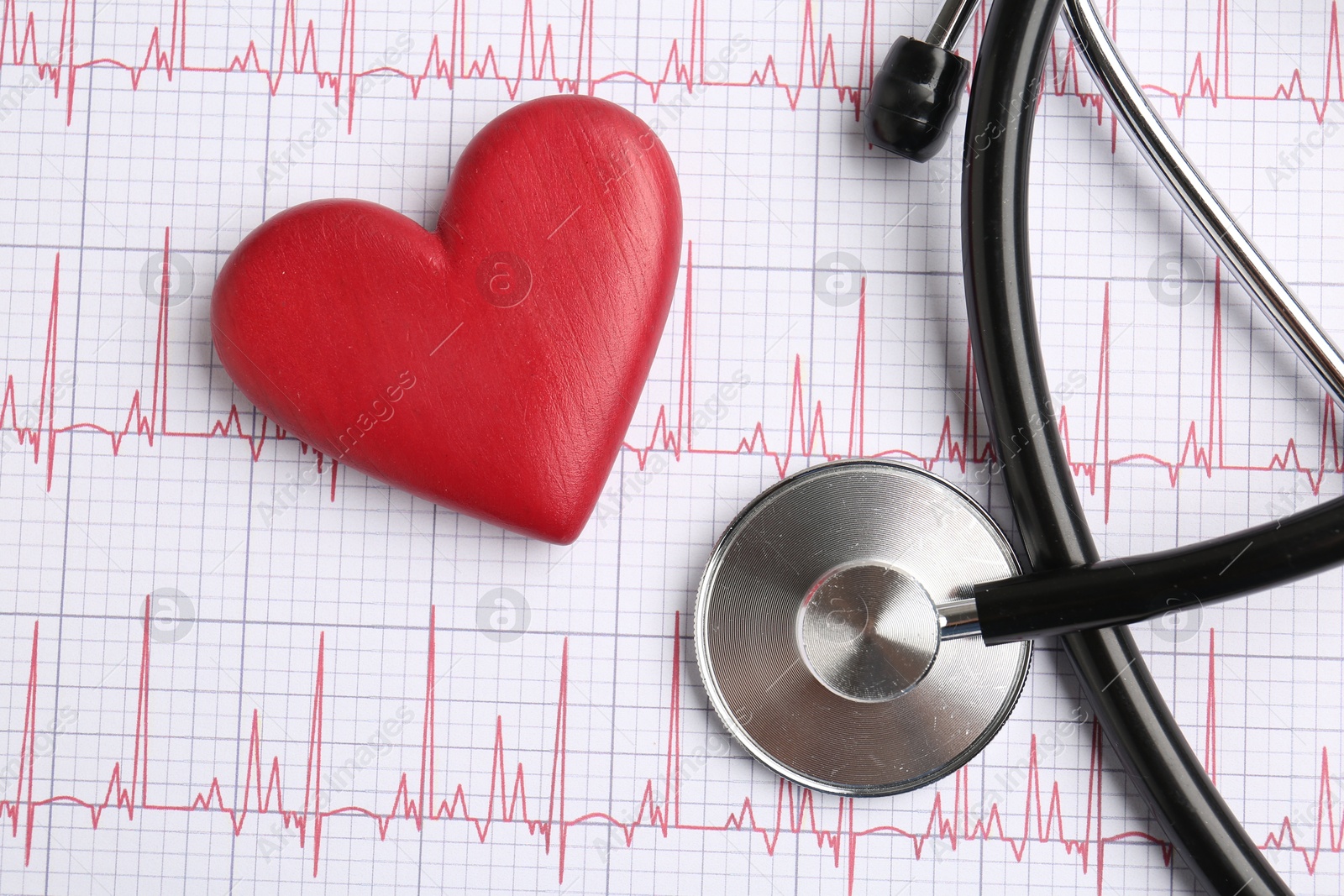 Photo of Cardiology. Stethoscope and red decorative heart on paper with cardiogram, flat lay