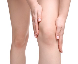 Photo of Young woman suffering from pain in knee on white background, closeup