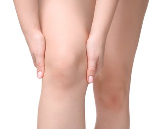 Photo of Young woman suffering from pain in knee on white background, closeup