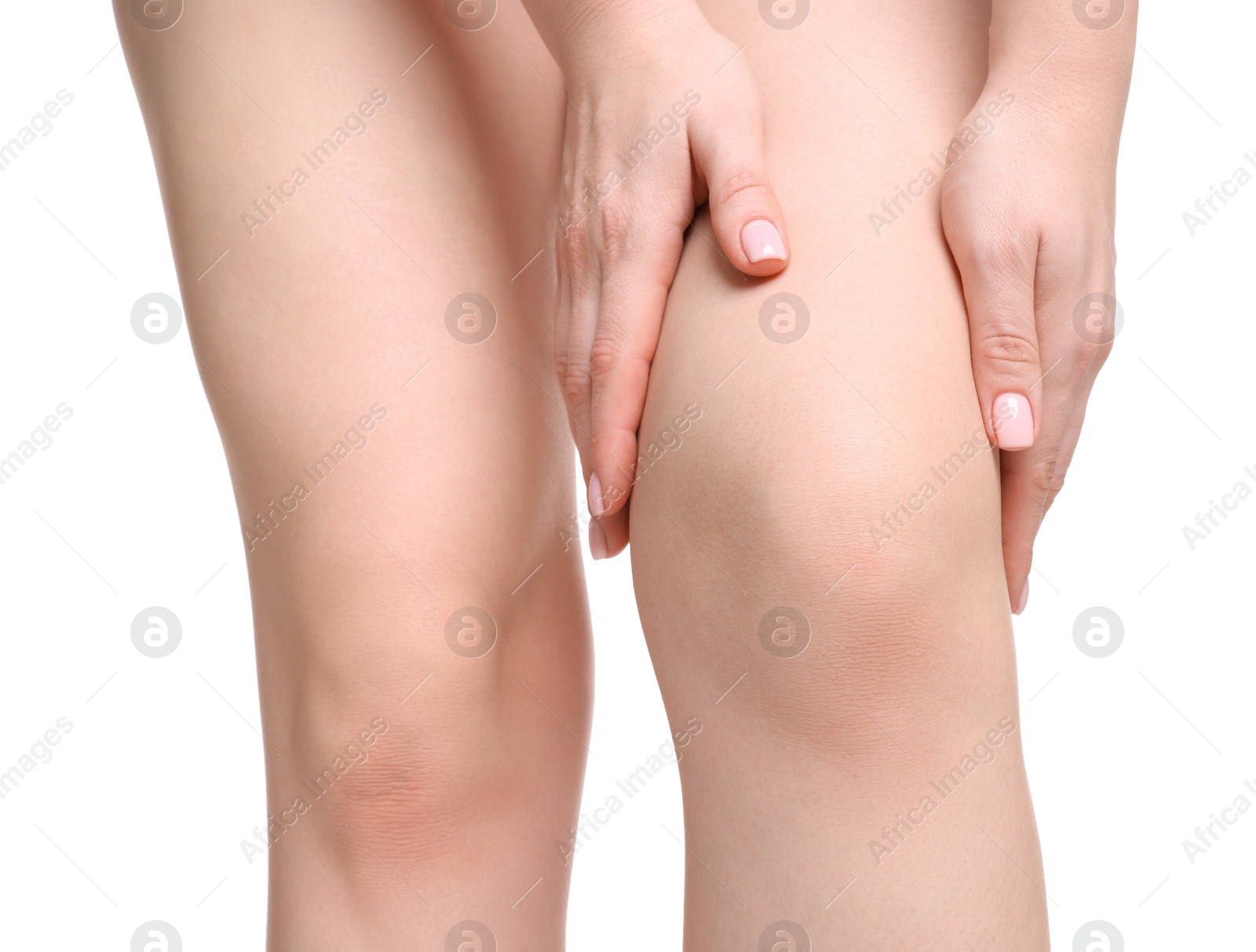 Photo of Young woman suffering from pain in knee on white background, closeup